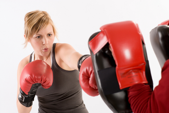 Young woman practicing boxing with her instructor